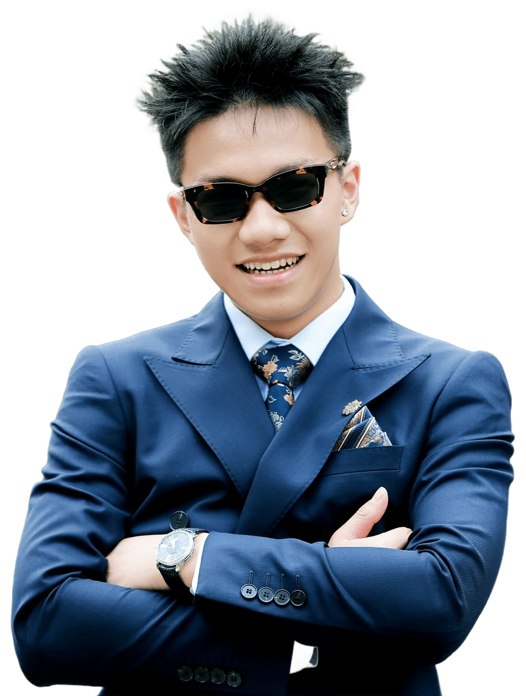 Austin Zhang in a navy suit and sunglasses, arms folded, cut out from the garden behind him.